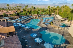A resort with multiple swimming pools, sun loungers, and umbrellas.