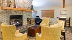 Un salon chaleureux avec une cheminée, des fauteuils confortables et une table basse.