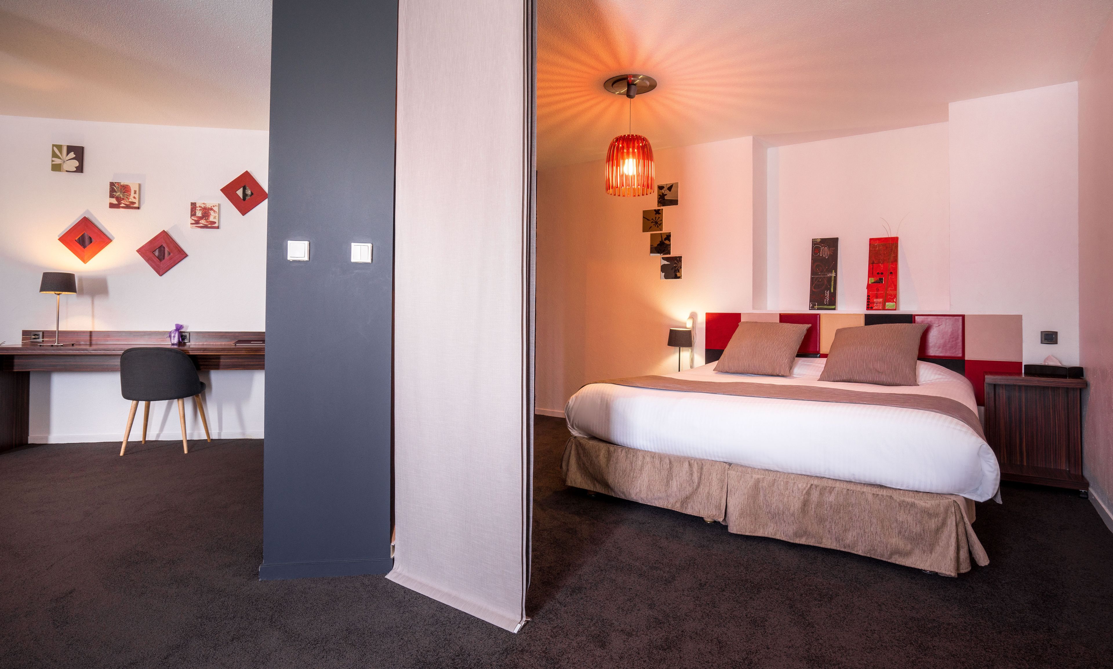Una habitación de hotel con cama, mesitas de noche, escritorio y silla.