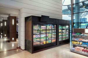 Una zona comercial moderna con vitrinas refrigeradas para bebidas y estanterías de aperitivos.