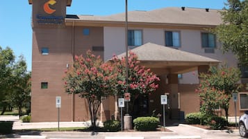 A Comfort Inn & Suites building with a modern design, including a prominent sign and a covered entrance.
