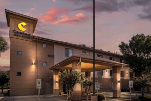 Um hotel Comfort Inn & Suites com design moderno, incluindo entrada coberta e estacionamento reservado para hóspedes com deficiência.