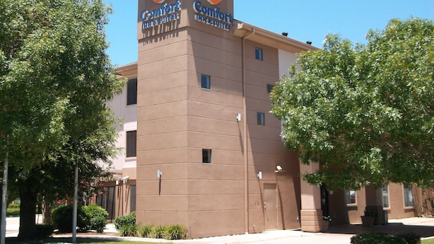 A Comfort Inn & Suites building with a brown facade, two visible windows, and a sign with a crescent moon logo. - Comfort Inn & Suites Seguin (Seguin)