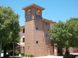 A Comfort Inn & Suites building with a brown facade, two visible windows, and a sign with a crescent moon logo. - Comfort Inn & Suites Seguin (Seguin)