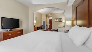 A hotel room with a large bed, a TV on a wooden dresser, a desk with a chair, and a mirror. - Comfort Inn & Suites Seguin (Seguin)