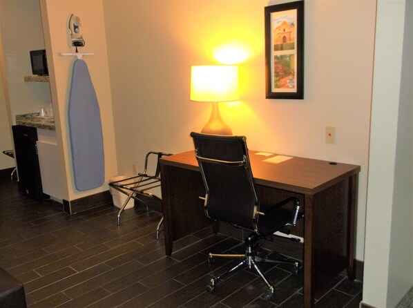 A small office space with a desk, chair, ironing board, and a lamp. - Comfort Inn & Suites Seguin (Seguin)