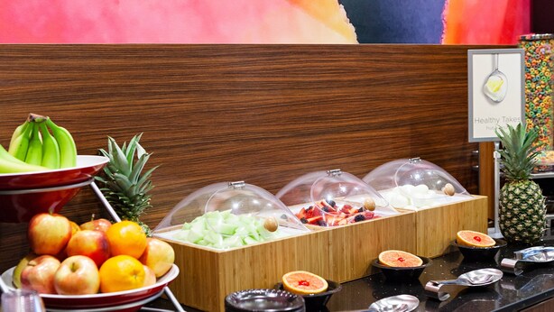 A breakfast buffet with various fruits and a sign indicating 'Healthy Takes'. - Fairfield Inn & Suites by Marriott Rockingham (Rockingham)