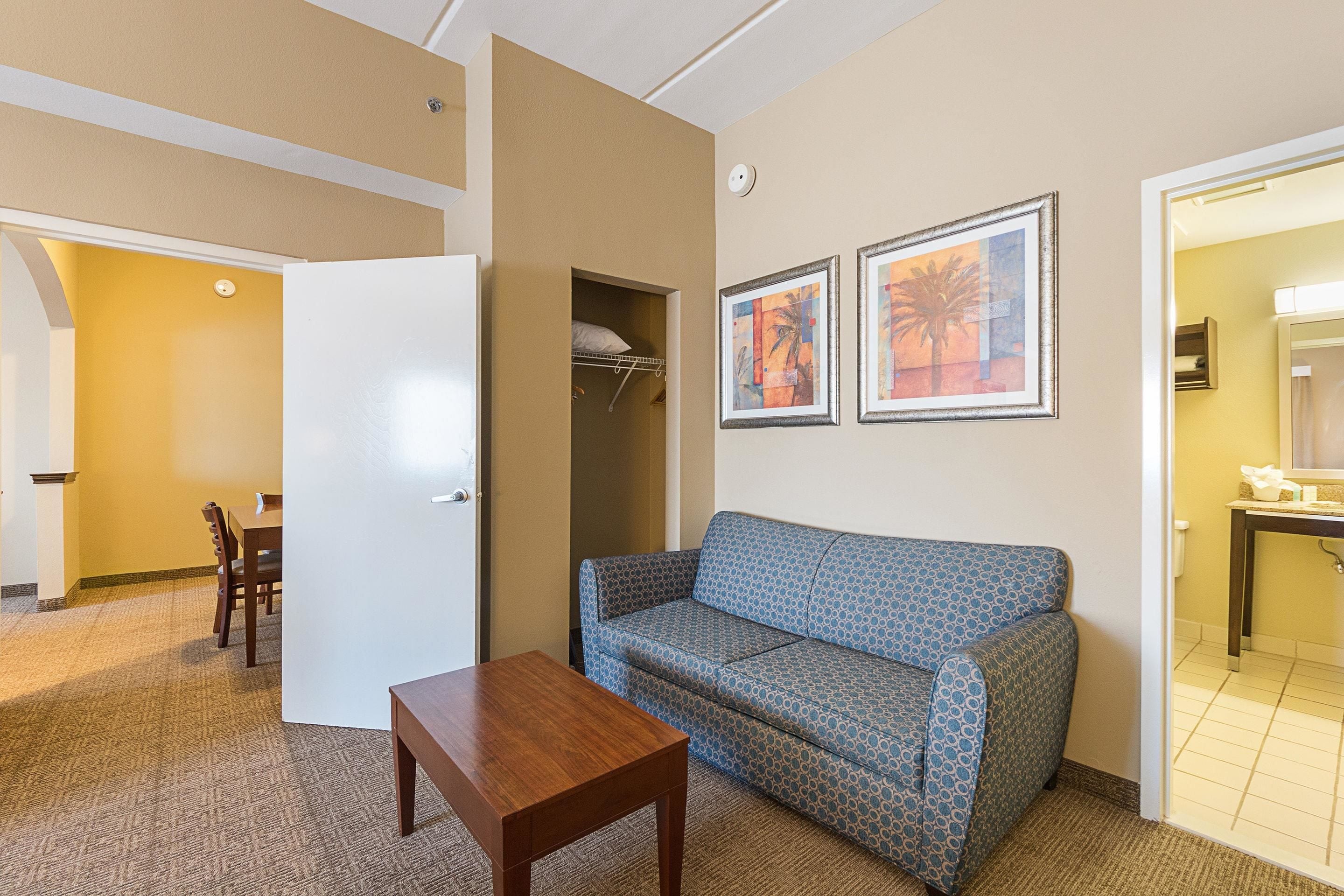 A compact living room with a sofa, a small table, and a dining area with chairs.