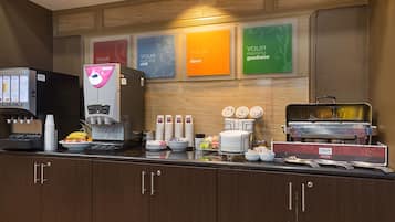 A breakfast bar with a coffee machine, a fruit bowl, and a sizzle station.
