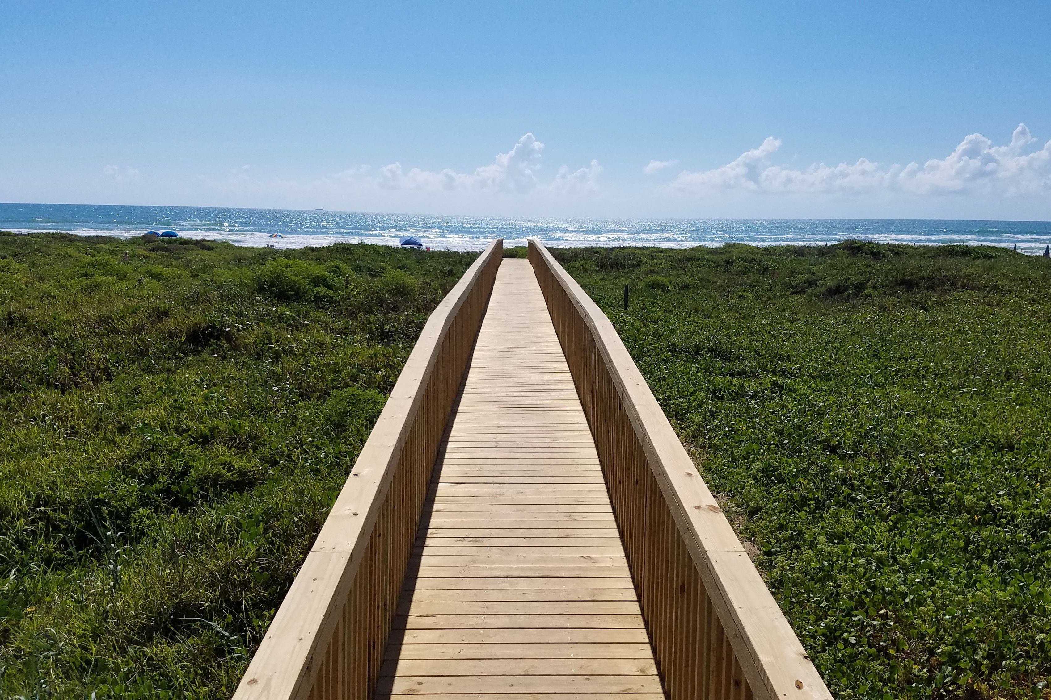 A wooden boardwalk leading to the beach.