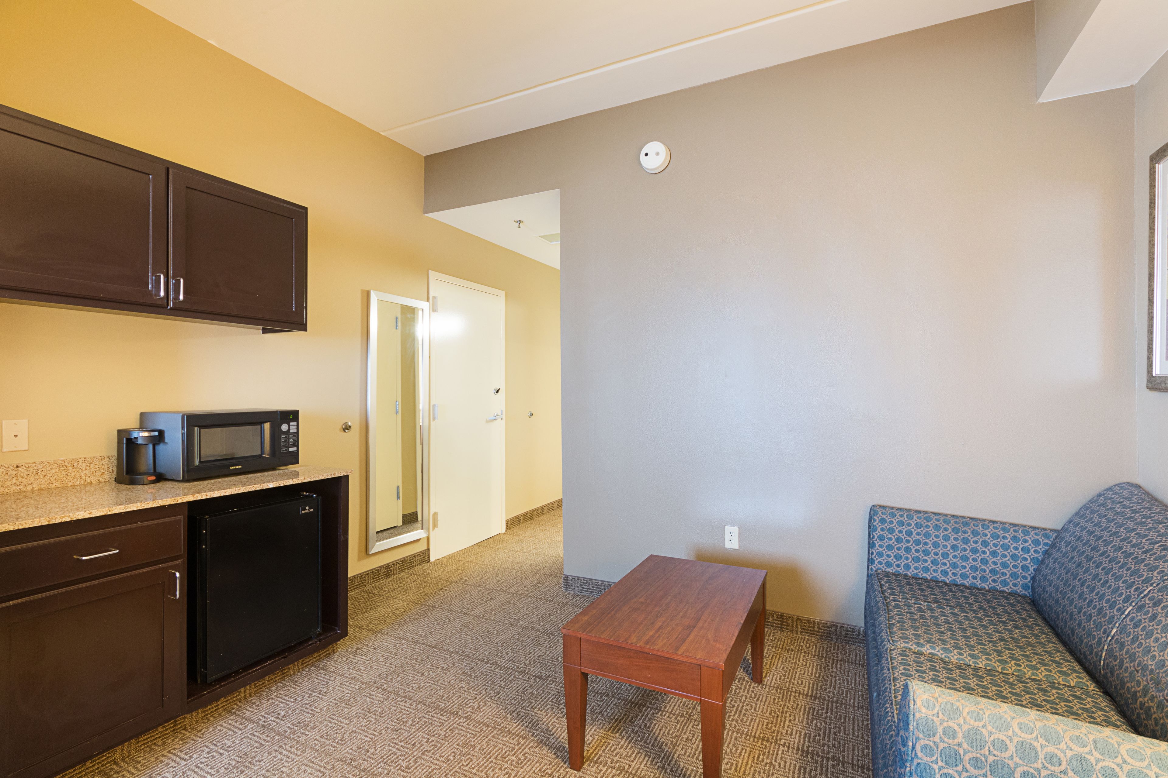 A compact living space with a kitchenette, a small table, and a sofa.
