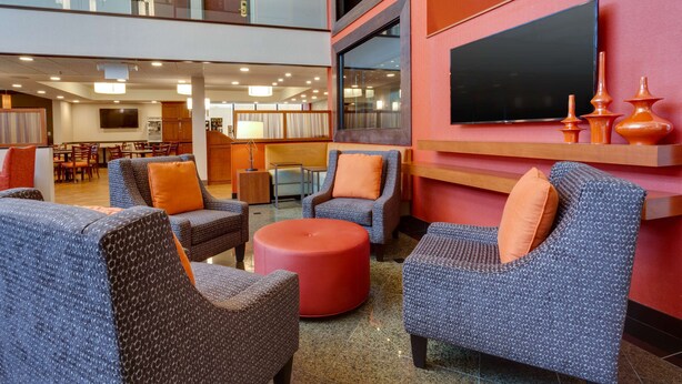 A spacious lobby with seating areas, a television, and a modern interior design. - Drury Inn & Suites Memphis Southaven (Horn Lake)