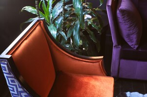 A room with a modern chair and a potted plant.