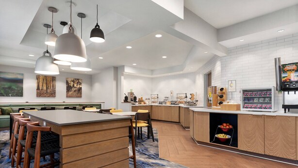 A modern kitchen with a central island, bar stools, pendant lighting, and a built-in refrigerator. - Fairfield Inn by Marriott Visalia Sequoia (Visalia)