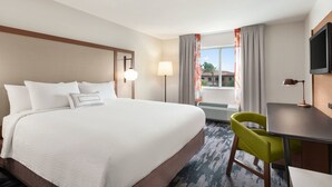 A hotel room with a large bed, a desk, a chair, a television, and a window with curtains. - Fairfield Inn by Marriott Visalia Sequoia (Visalia)