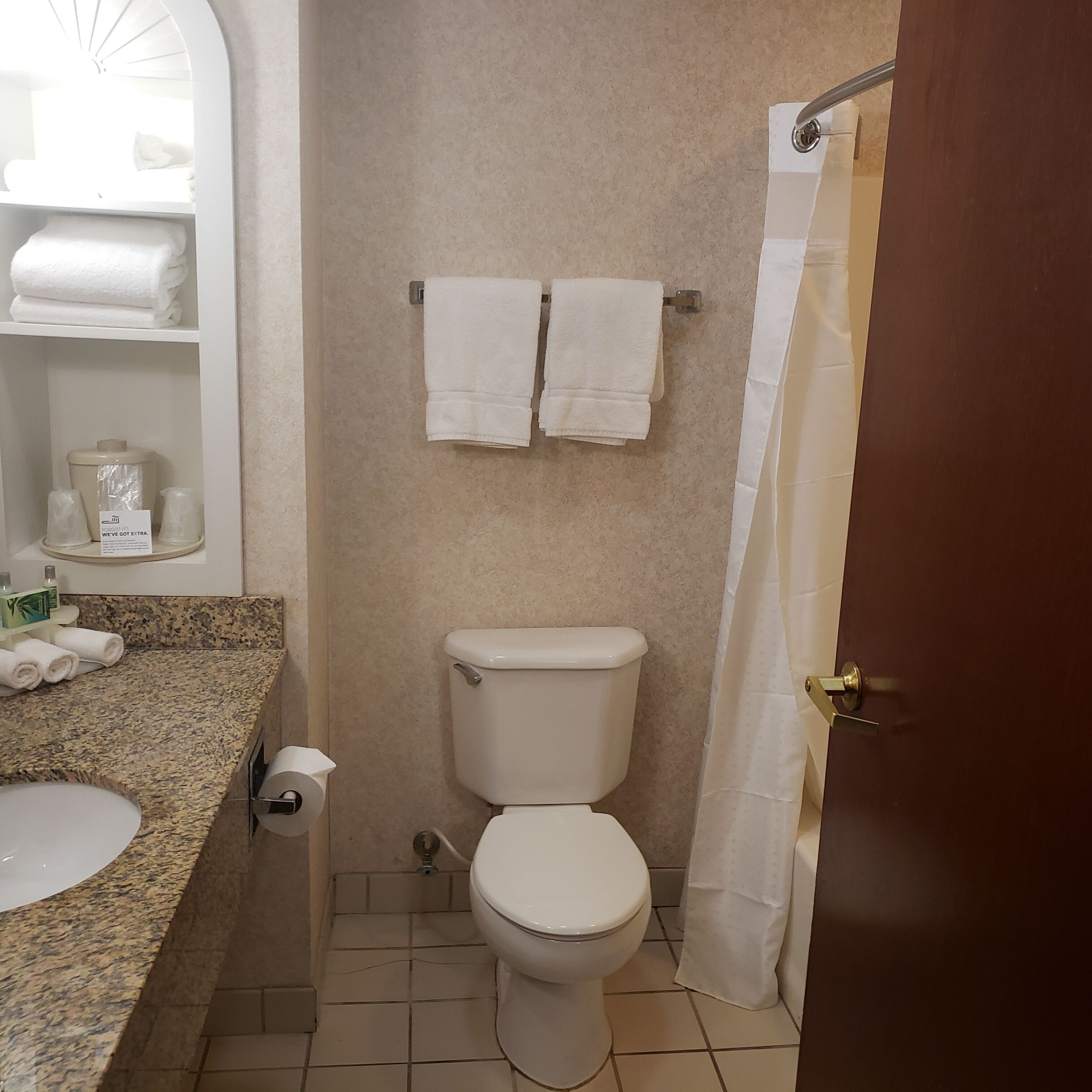 Une salle de bain équipée de toilettes, d’un lavabo et d’un porte-serviettes.
