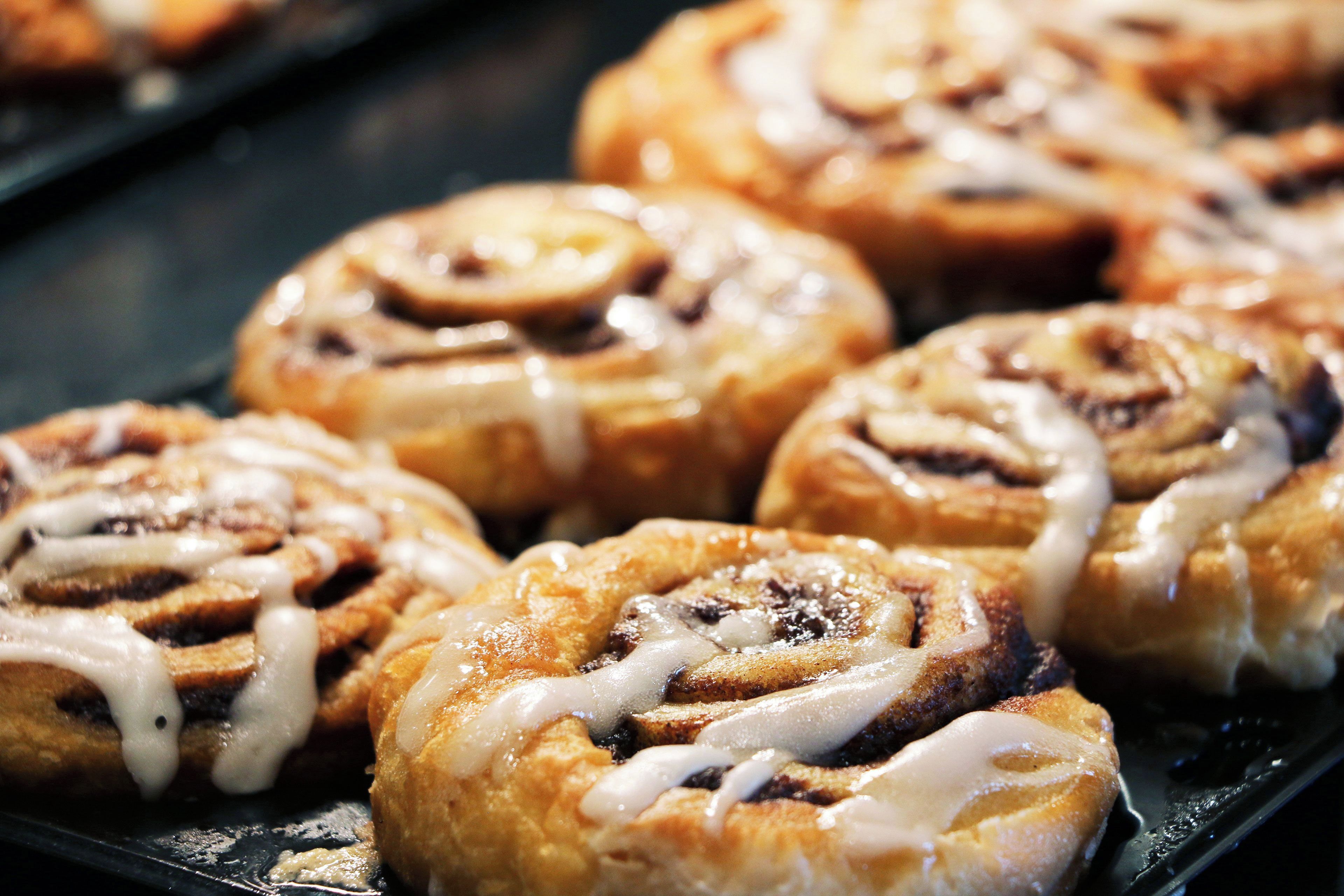 A tray of cinnamon rolls with icing.