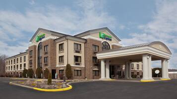 Un hotel Holiday Inn Express con entrada cubierta y estacionamiento.