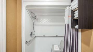 A shower area with a white bathtub, a showerhead, a grab bar, a towel rack, and a striped curtain.