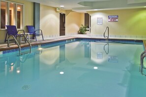 An indoor swimming pool with clear water, a lifeguard sign, and lounge chairs. - La Quinta Inn & Suites by Wyndham Hot Springs (Hot Springs)