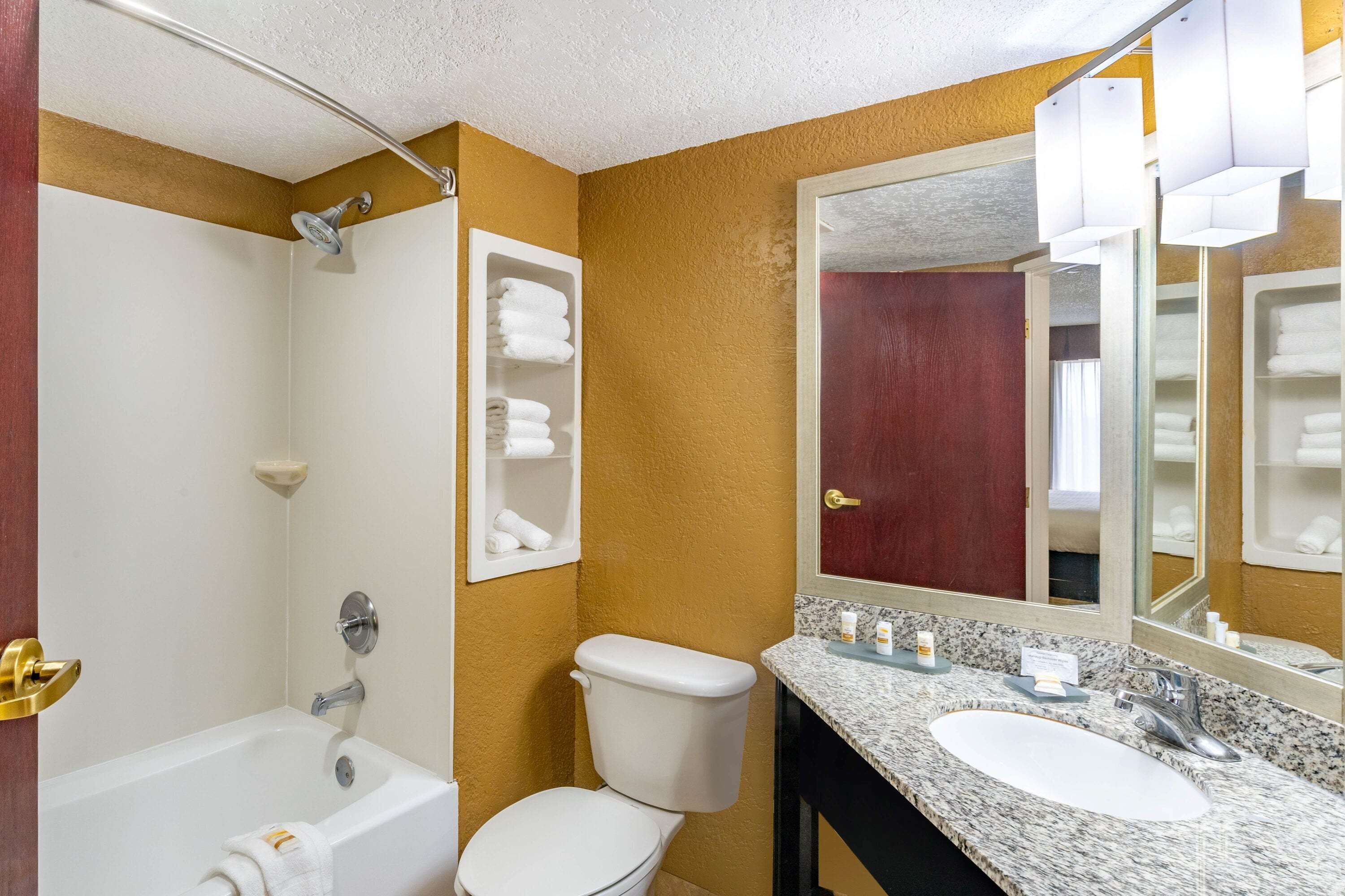 A bathroom with a bathtub, toilet, and sink.