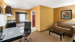 A hotel room with a kitchenette, a sofa, a coffee table, a desk, and a chair. - La Quinta Inn & Suites by Wyndham Hot Springs (Hot Springs)