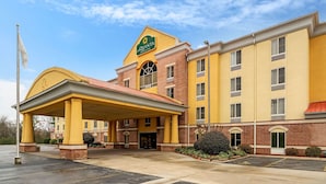 A La Quinta hotel with a yellow facade, a covered entrance, and a parking lot. - La Quinta Inn & Suites by Wyndham Hot Springs (Hot Springs)