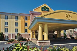 A hotel with a yellow facade, a prominent sign, and a covered entrance area. - La Quinta Inn & Suites by Wyndham Hot Springs (Hot Springs)