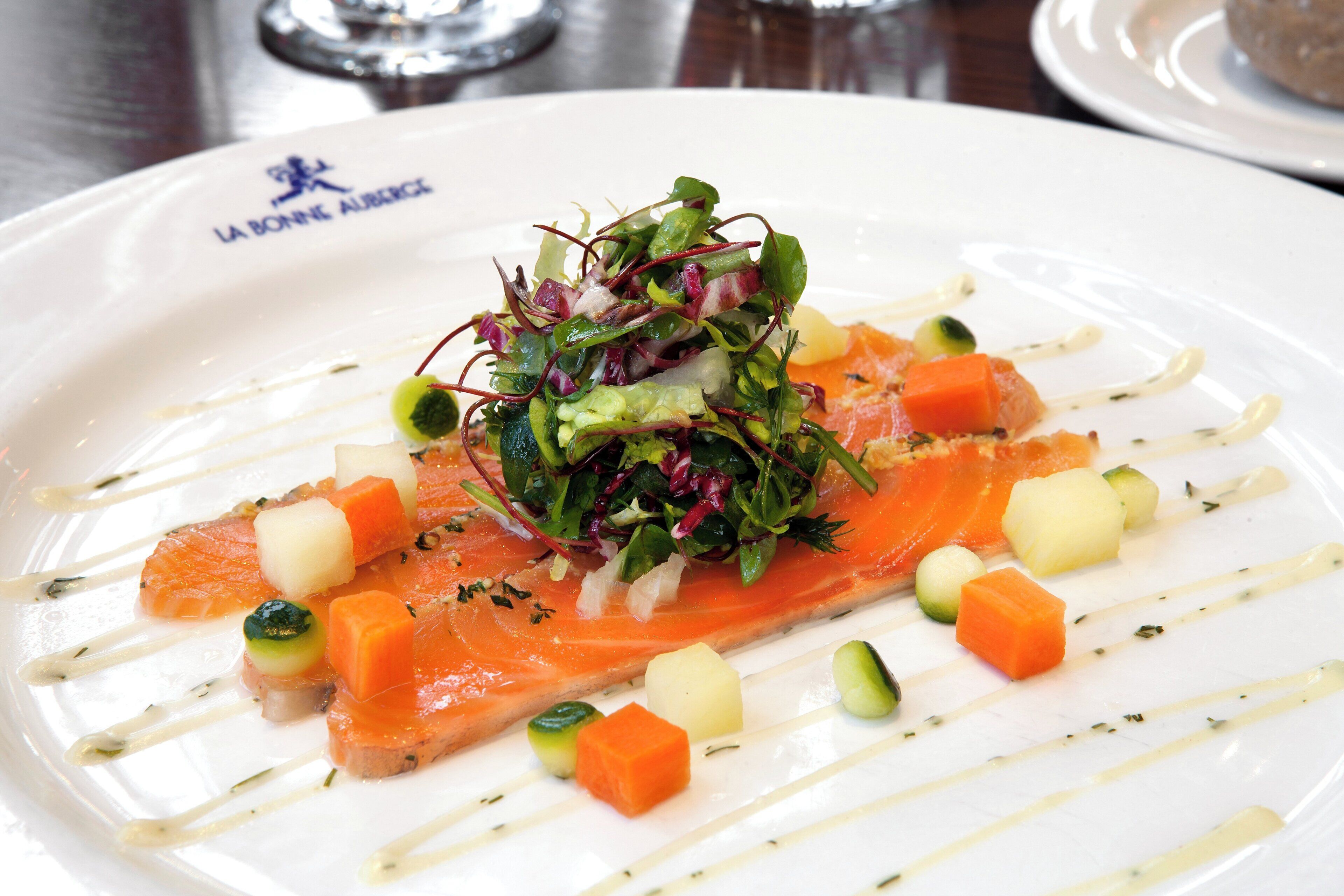 Un piatto di cibo con salmone e verdure.