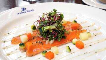 Un plato de comida con salmón y verduras.