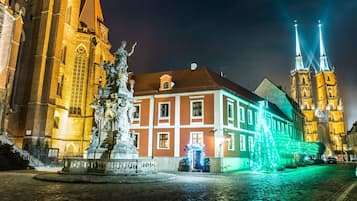 Un edificio histórico con una torre destacada y una estatua al frente.