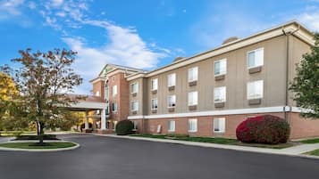 A multi-story hotel with a brick facade, large windows, and a covered entrance.