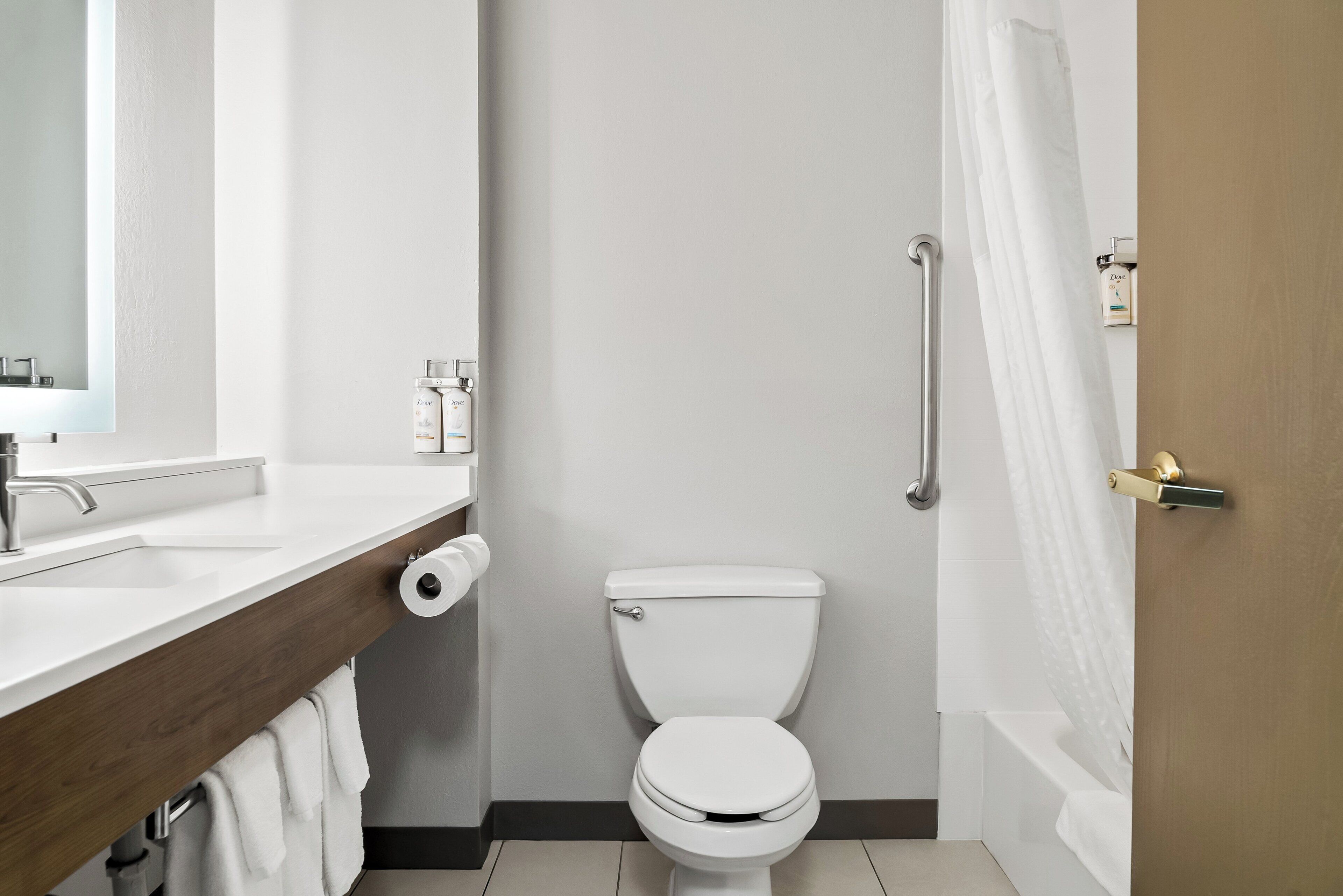 Ein Badezimmer mit einer weißen Toilette, einem Waschbecken mit Spiegel und einer Duschkabine.