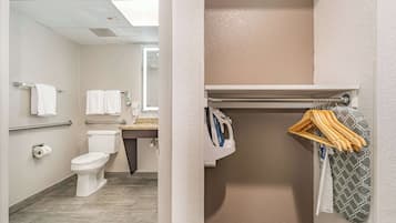 Een badkamer met toilet, handdoekhouders en een douchegedeelte met een handdoekhouder.