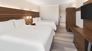 A hotel room with two beds, a TV, wooden headboard, and a walk-in closet. - Holiday Inn Express & Suites Byron by IHG (Byron)