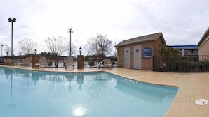 A swimming pool with lounge chairs and a small building with a sign. - Holiday Inn Express & Suites Byron by IHG (Byron)