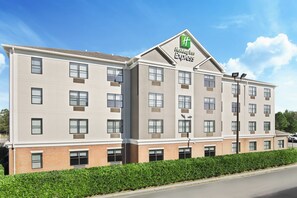 A Holiday Inn Express hotel with a brick facade, multiple windows, and a green logo. - Holiday Inn Express & Suites Byron by IHG (Byron)