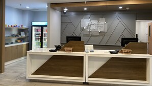 A hotel reception desk with a modern design, a glass display case, and a sign for Holiday Inn Express & Suites. - Holiday Inn Express Hotel & Suites Plymouth by IHG (Plymouth)