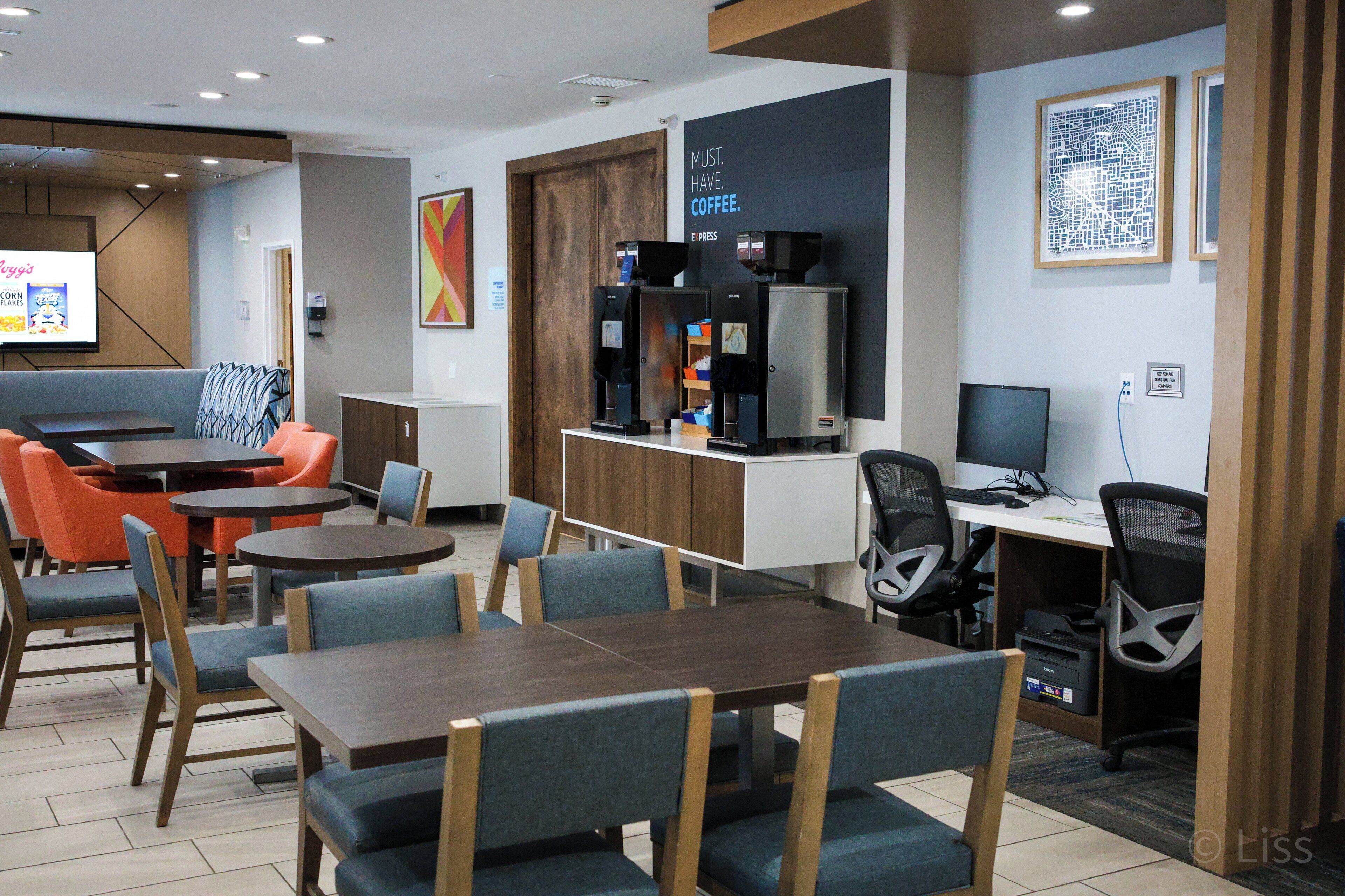 Un café moderne doté d’un espace salon, de machines à café et d’un écran de présentation.