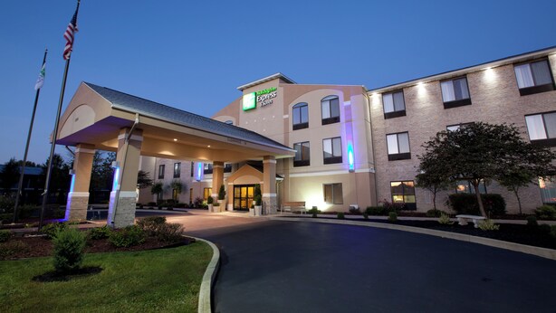 A Holiday Inn Express & Suites building with a covered entrance, multiple windows, and a flagpole. - Holiday Inn Express Hotel & Suites Plymouth by IHG (Plymouth)