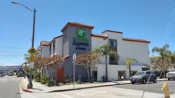 Een Holiday Inn Express & Suites gebouw met een heldere blauwe lucht.