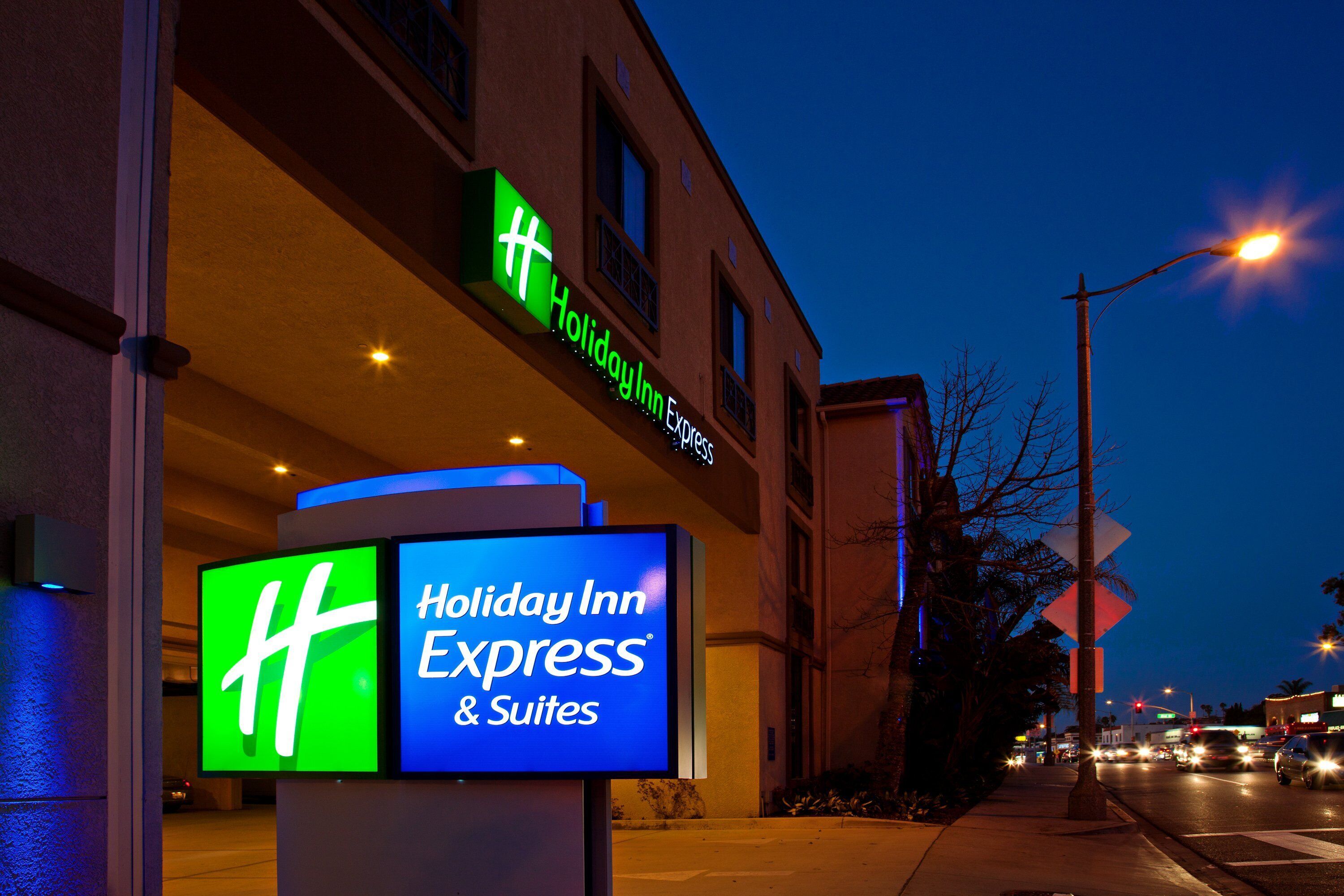 Un letrero de Holiday Inn Express & Suites con un logotipo 'H' destacado, que identifica la cadena hotelera.