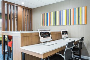 A conference room with two desktop computers, a wooden desk, and a colorful striped wall. - Holiday Inn Express Plymouth by IHG (Plymouth)