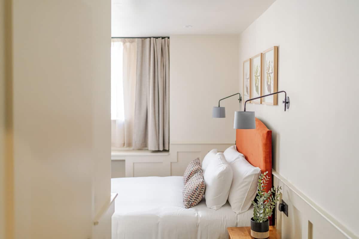 Escritorio, cortinas blackout y tabla de planchar con plancha