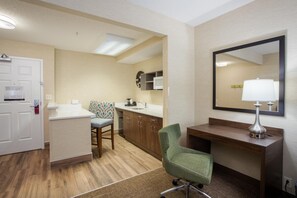 A hotel room with a kitchenette, a desk with a mirror, a chair, and a small bathroom. - Hampton Inn Buffalo South/I-90 (Buffalo)