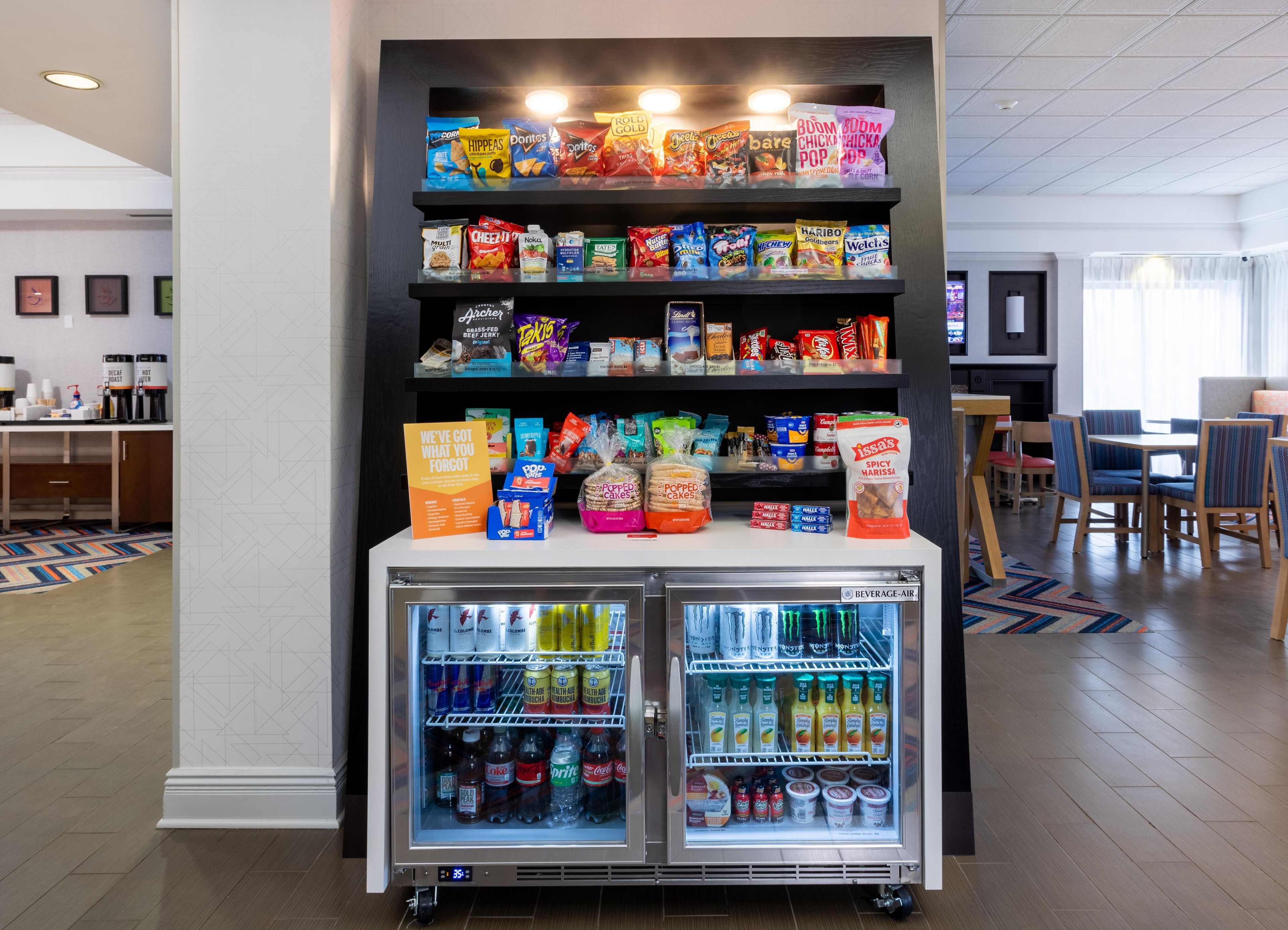 A vending machine stocked with snacks and beverages in a hotel lobby.