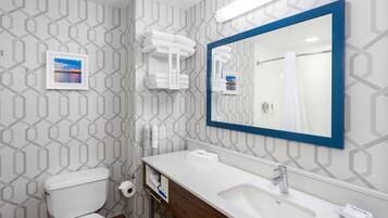 A bathroom with a toilet, sink, mirror, towel rack, and a picture on the wall.