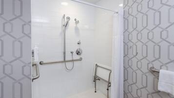 Um chuveiro com barras de apoio, porta-toalhas e um chuveiro.