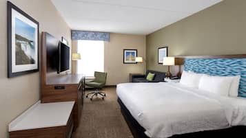Une chambre d’hôtel équipée d’un lit, d’un bureau, d’une chaise, d’une télévision et de deux lampes.