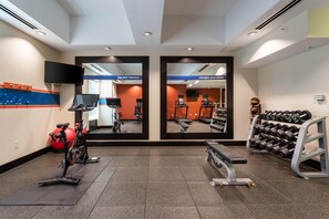 A gym with exercise equipment, mirrors, and a television. - Hampton Inn Buffalo South/I-90 (Buffalo)